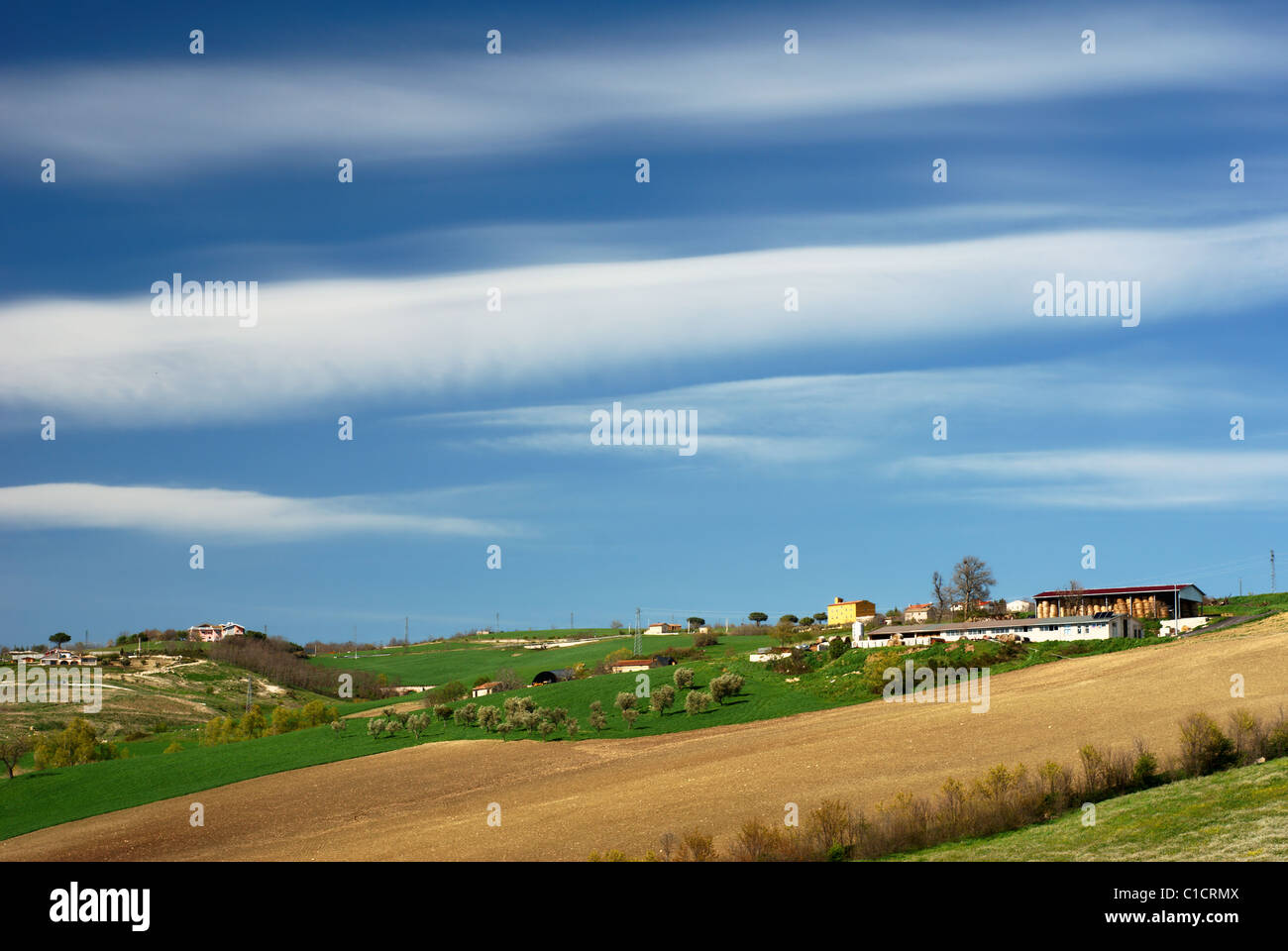 Paysage rural avec ferme sur haut de loin hillside Banque D'Images