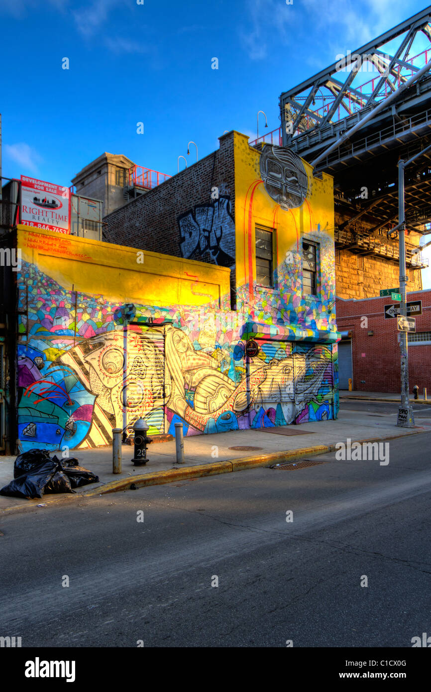 Graffit couverts immeuble à côté du pont de Williamsburg à Brooklyn, New York au coucher du soleil Banque D'Images