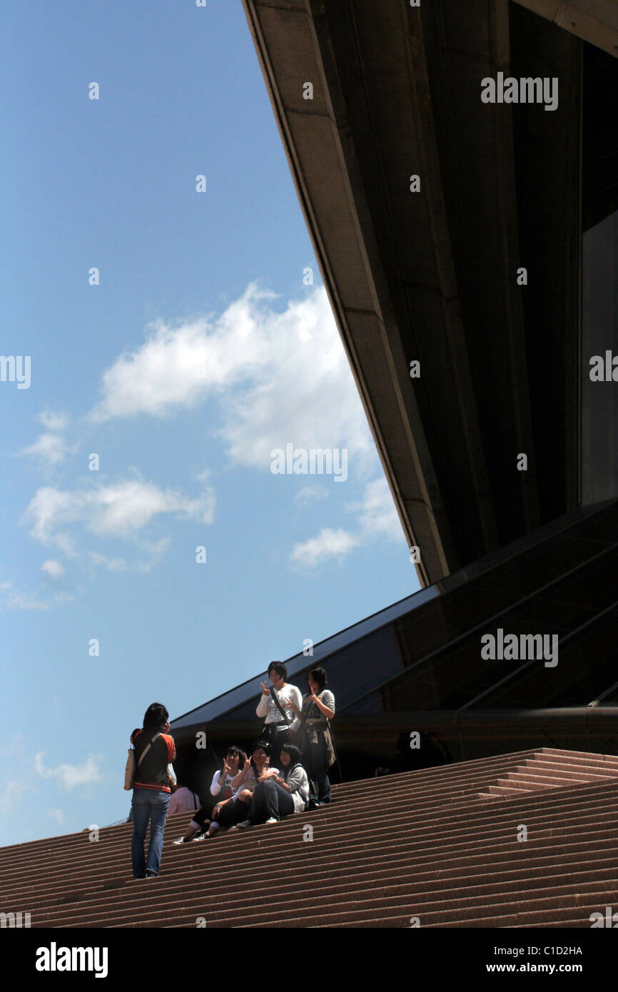 Les touristes s'asseoir sur les marches de l'Opéra de Sydney, Sydney, NSW, Australie Banque D'Images