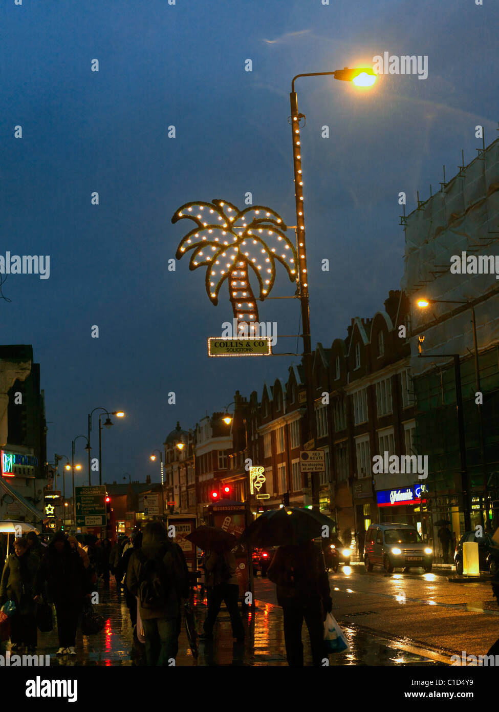 Tooting London Angleterre Personnes Shopping à Tooting High Street la nuit sous la pluie feux Eid Banque D'Images