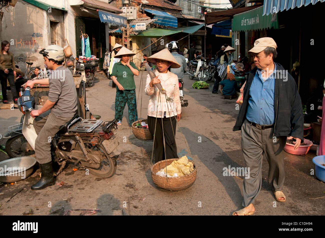 Les gens se promener dans une rue animée dans le vieux quartier du marché Hanoi Vietnam Banque D'Images