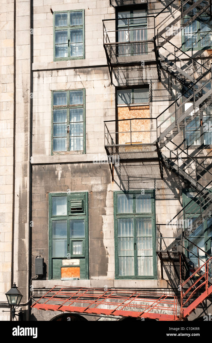 Une scène commune dans le vieux Montréal ; un escalier de secours en acier s'étend le long de l'extérieur de ce bâtiment patrimonial. Banque D'Images