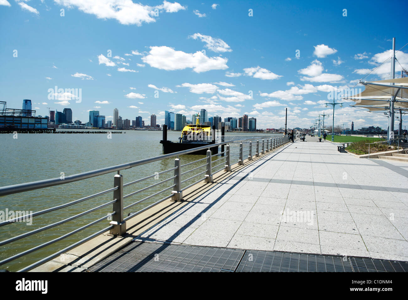New York skyline sous ciel bleu avec un bateau-taxi jaune de New York. Banque D'Images