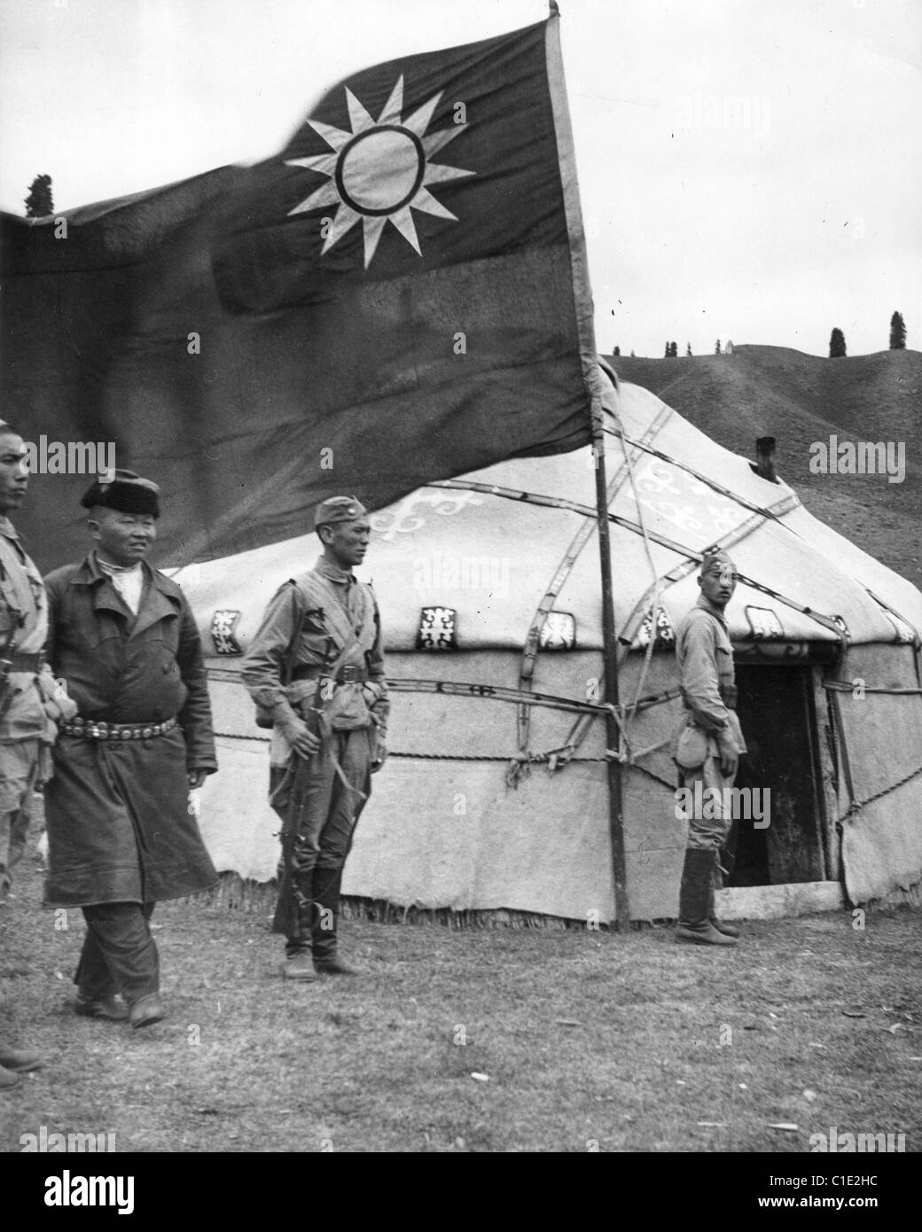 La guerre sino-japonaise de l'armée chinoise avec les dirigeants kazakhs à l'intérieur d'une yourte avec le drapeau nationaliste à l'extérieur - vers 1940 Banque D'Images