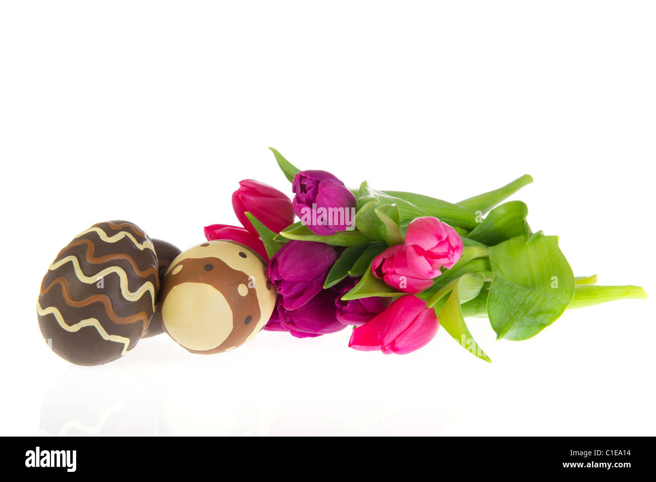 Les oeufs de pâques en chocolat avec tulipes colorées au printemps Banque D'Images