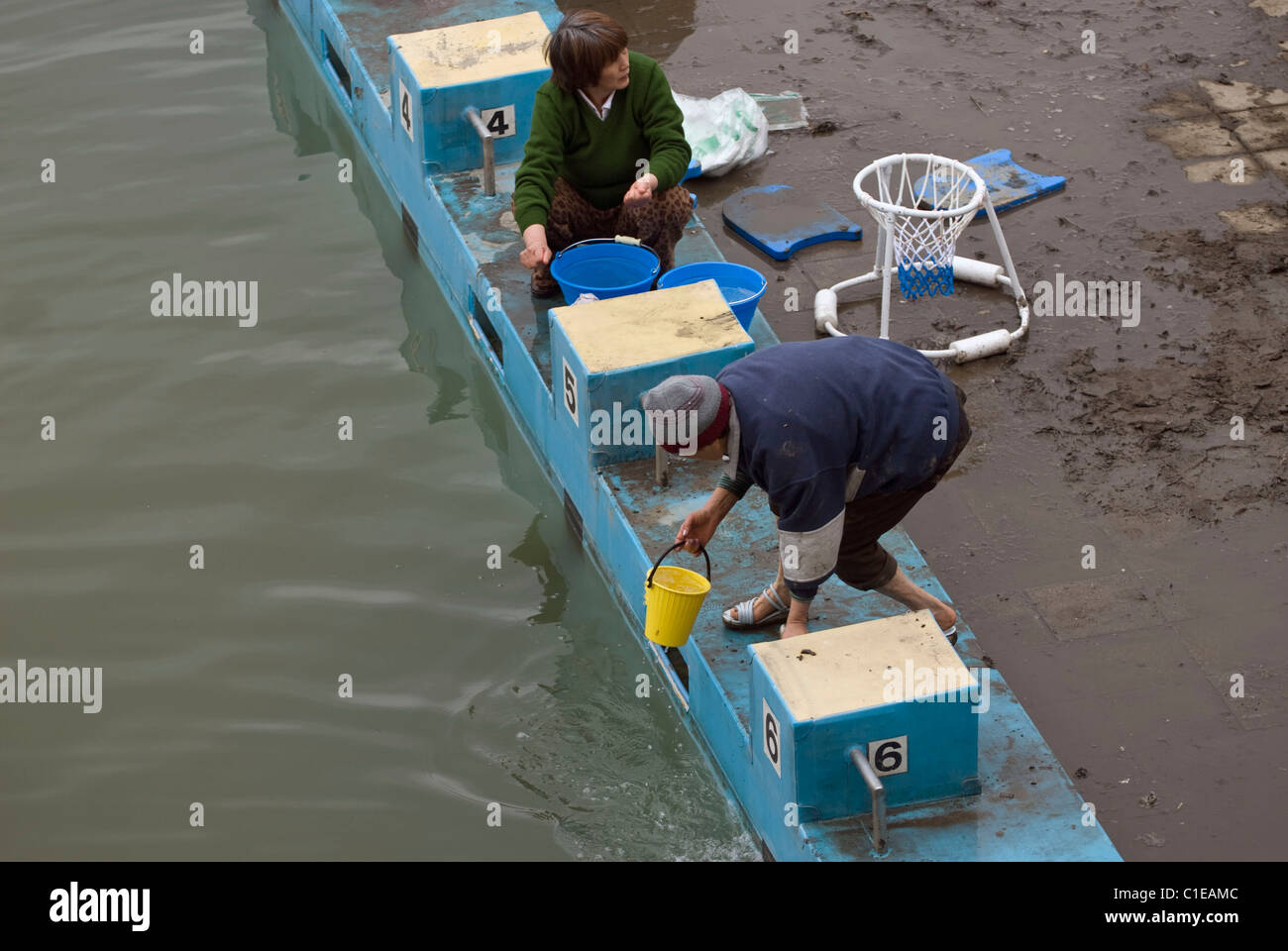 Les résidents ont sans-abri par le séisme et le tsunami du 11 mars remplir des seaux avec de l'eau de la piscine de l'école élémentaire Banque D'Images