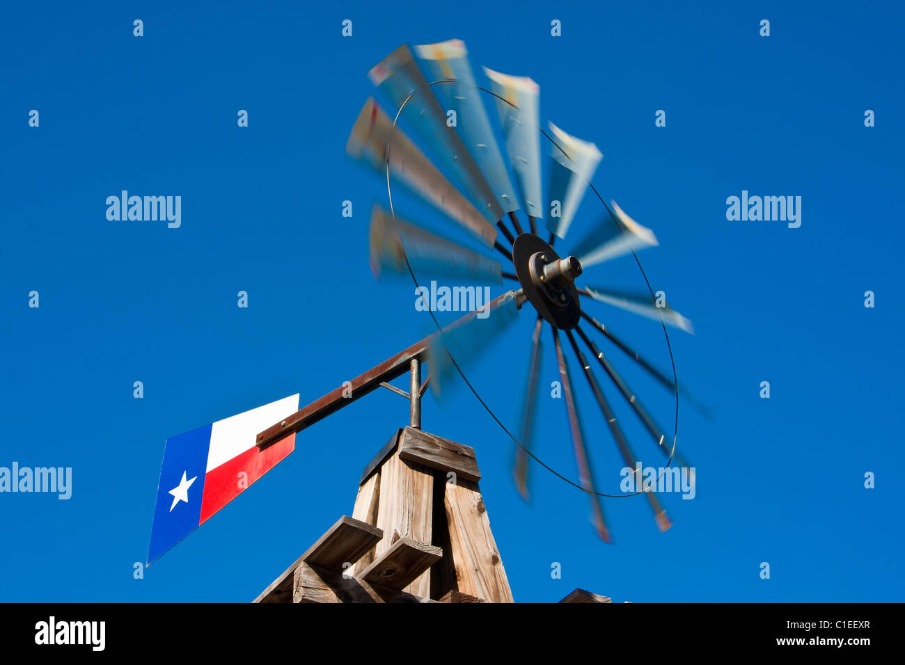 Un moulin à vent avec un drapeau du Texas, que l'on retrouve normalement sur une ferme, monté à l'avant de l'historique hôtel Rogers, San Marcos, Texas. Banque D'Images