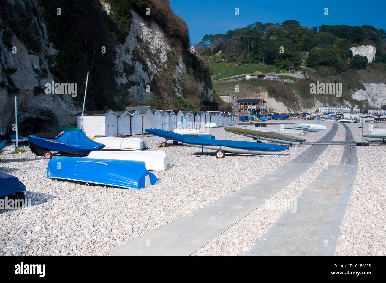 Cabines de plage et des bateaux à voile sur la plage de la bière dans le Devon, England, UK Banque D'Images