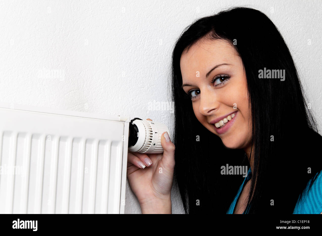 Femme avec un radiateur de chauffage et thermostat Banque D'Images