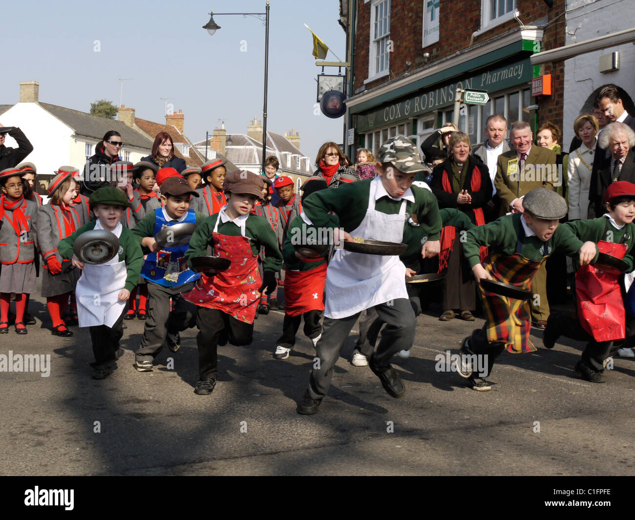 Les jeunes garçons en compétition dans une course de crêpes à Olney Buckinghamshire Angleterre Le Mardi Gras Banque D'Images