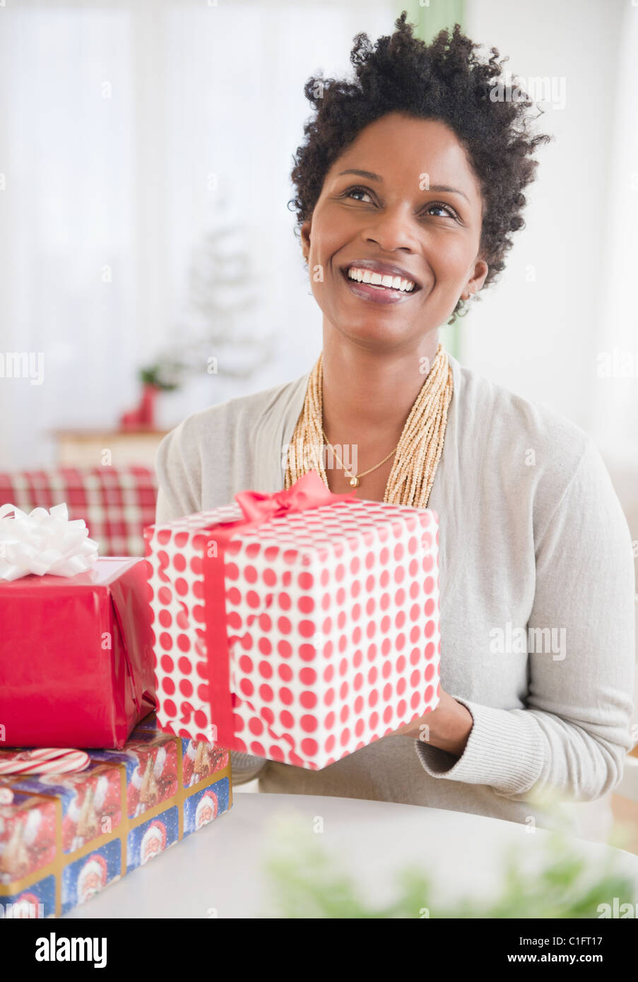 Black woman holding wrapped gift Banque D'Images
