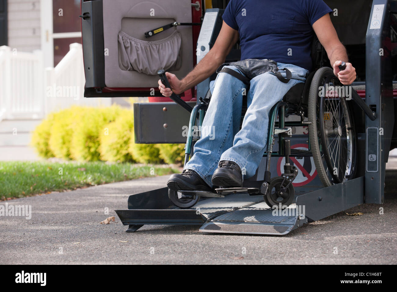 L'homme avec de la moelle épinière dans un fauteuil roulant obtenir dans sa fourgonnette accessible Banque D'Images