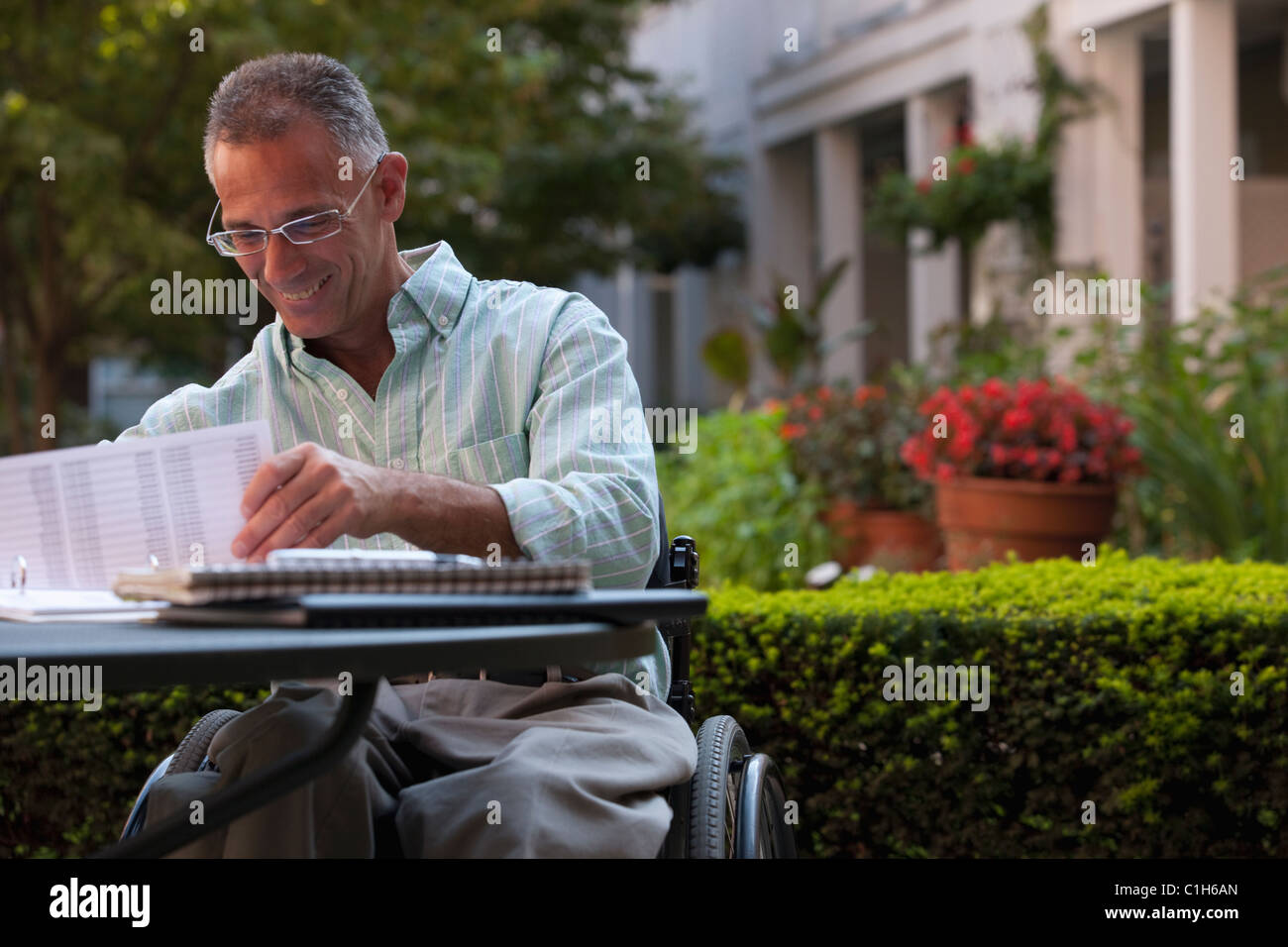 Businessman with spinal cord injury travaillant sur des documents dans un café Banque D'Images
