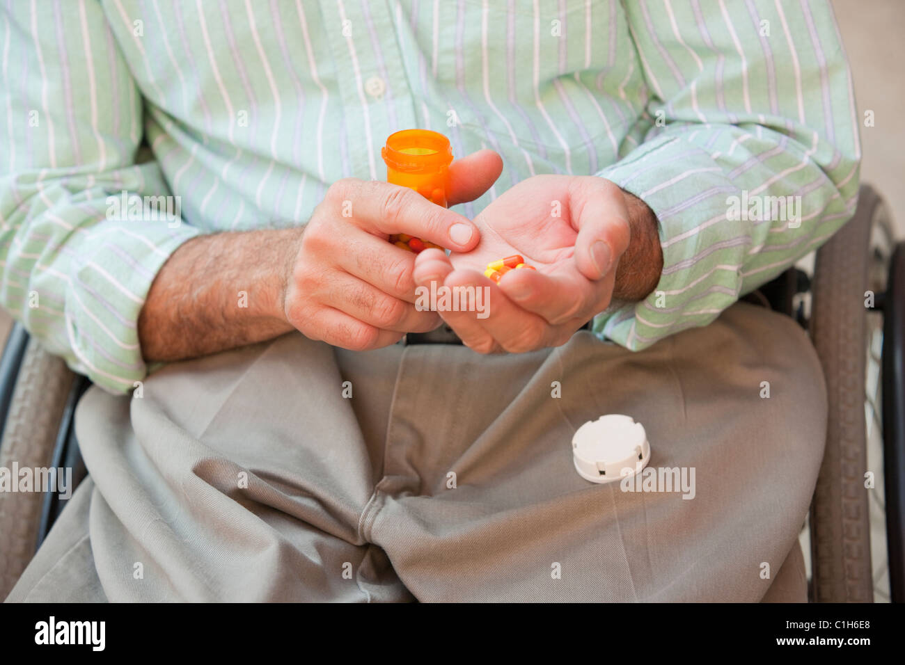 L'homme avec de la moelle épinière dans un fauteuil roulant prennent des médicaments Banque D'Images