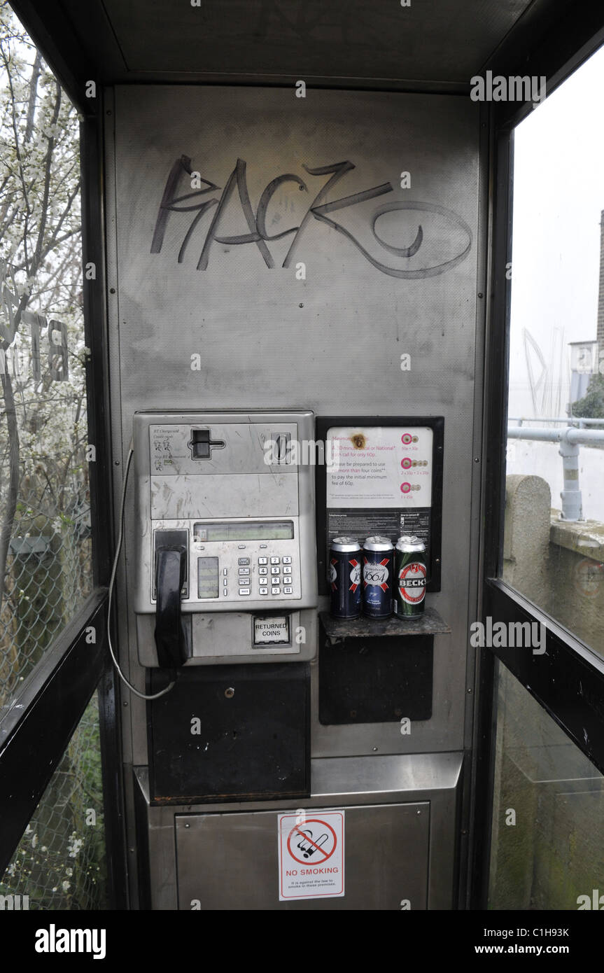 Une vue générale d'une sale téléphone public fort de graffitis et de restes de cannettes de bière Banque D'Images