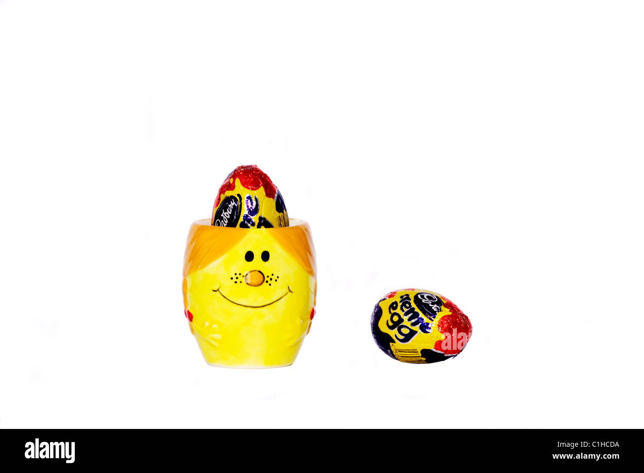 Cadburys creme oeufs dans un Little Miss Sunshine egg cup Banque D'Images