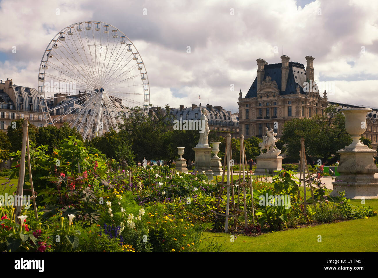 Jardin de fleurs aux couleurs vives, des statues et le carrousel Immeuble Richelieu vue depuis le jardin des Tuileries au Louvre Paris France Banque D'Images