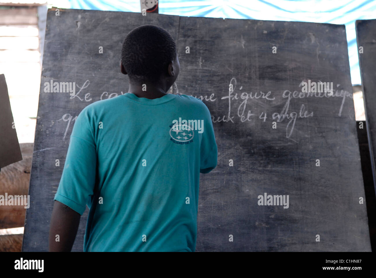 Un ancien enfant-soldat écrit le français sur un tableau de surveillance au Centre de transit et d'orientation pour les anciens enfants-soldats exploités par le CAJED, une ONG congolaise soutenue par l'UNICEF qui travaille avec des enfants et des jeunes défavorisés dans la ville de Goma. Province du Nord-Kivu RD Congo Afrique Banque D'Images