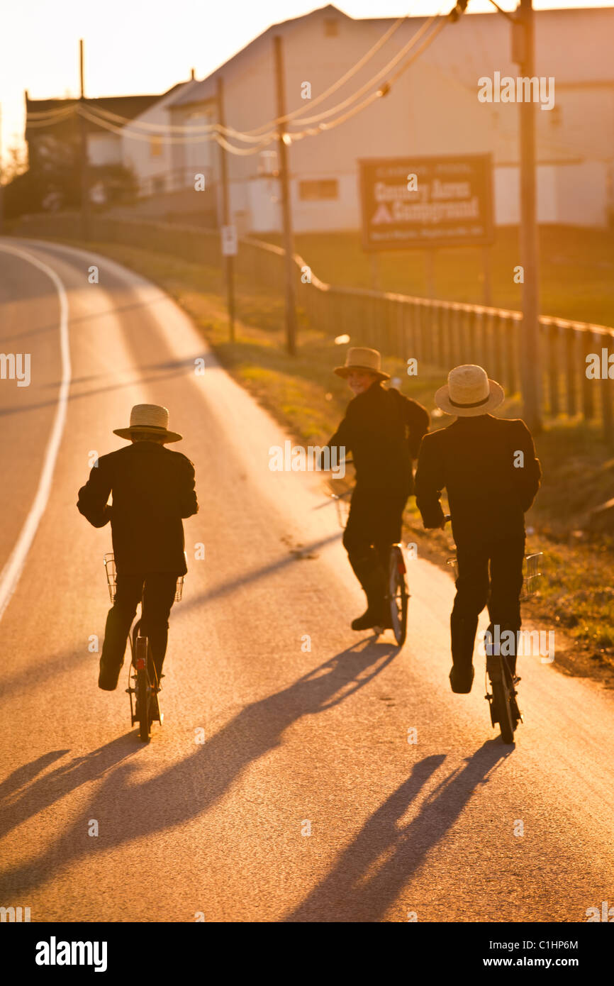 Les enfants Amish ride pousser des scooters à l'église pendant le lever du soleil à Bird in Hand, PA. Banque D'Images