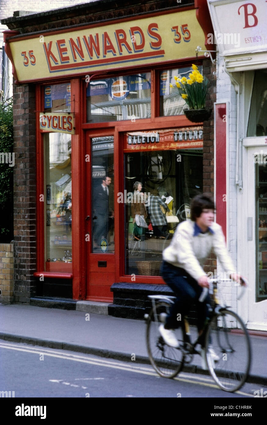Un jeune adolescent d'une bicyclette d'Kenwards fenêtre passé Boutique de Cycle à Royal Tunbridge Wells, Kent England UK des années 70, 1972 KATHY DEWITT Banque D'Images