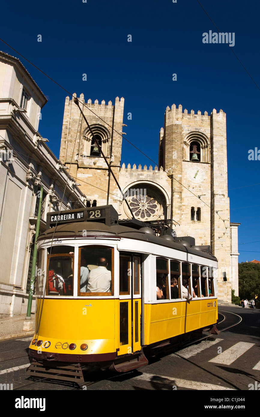 Le Tram 28, la célèbre friendly scenic line qui passe par Lisbonne, passe devant la cathédrale (Se) dans le quartier d'Alfama dis Banque D'Images