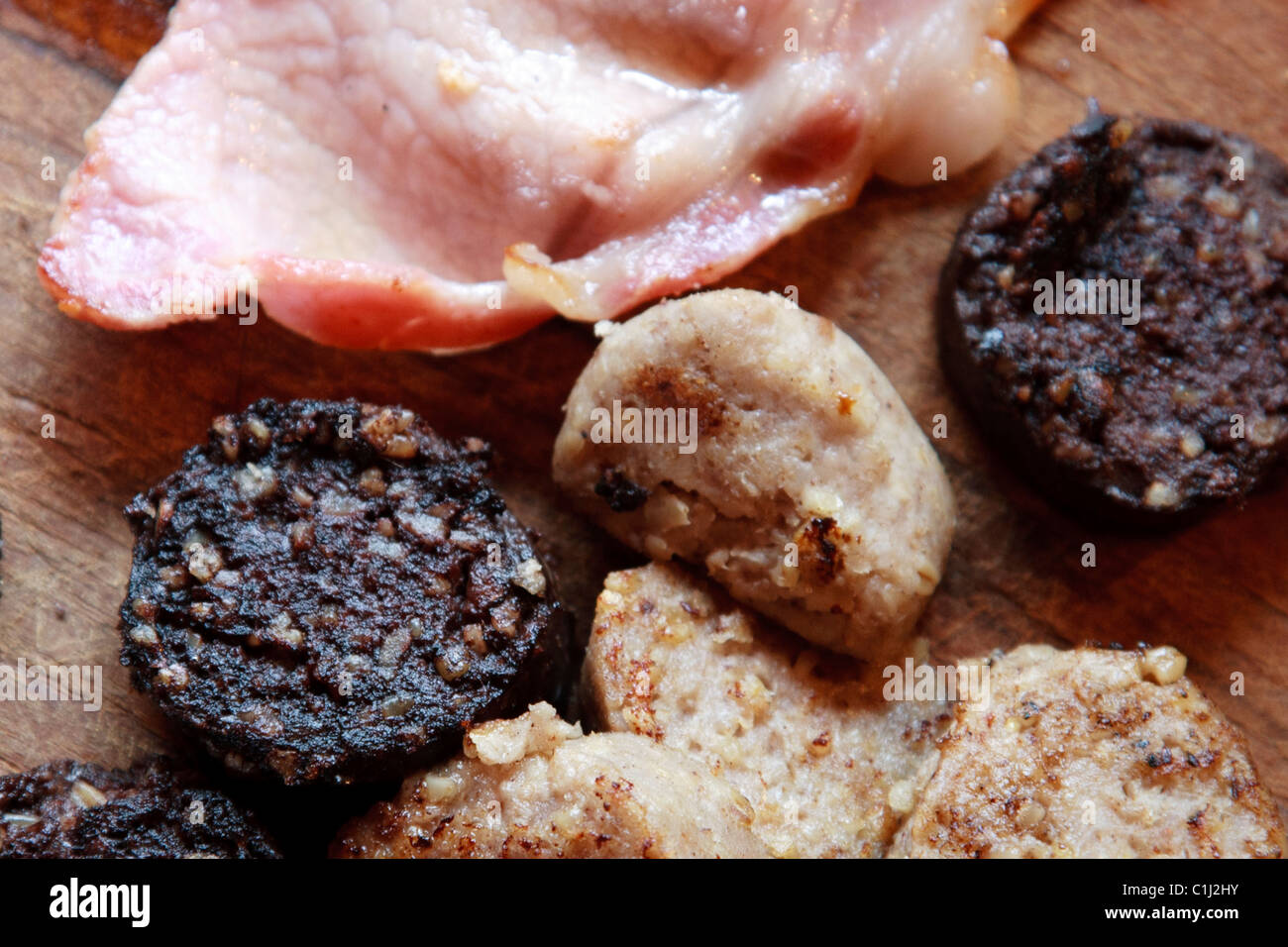 Boudin blanc, boudin noir et tranches de bacon sur conseil cuisine en bois Banque D'Images