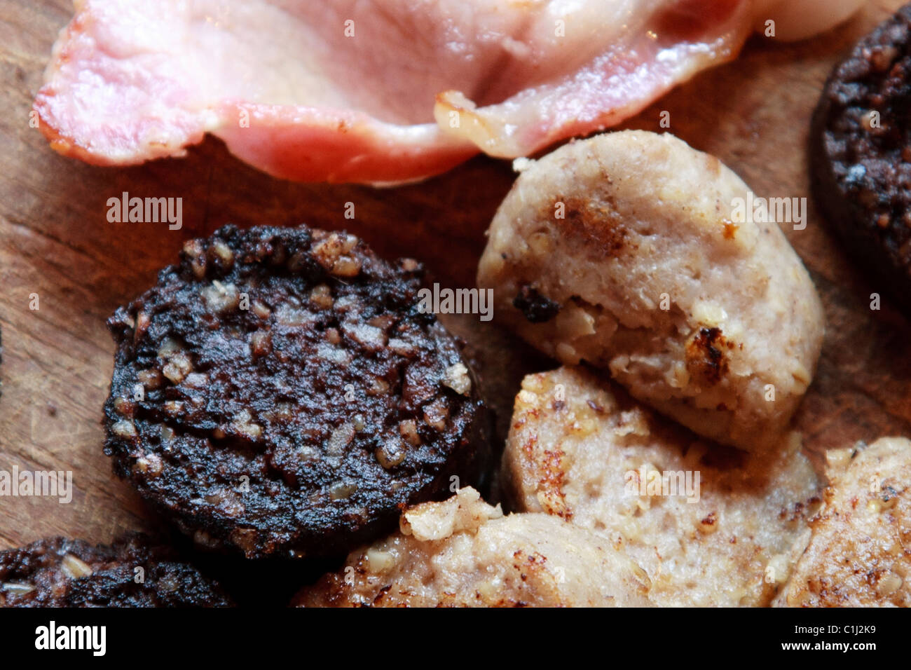 Boudin blanc, boudin noir et tranches de bacon sur conseil cuisine en bois Banque D'Images
