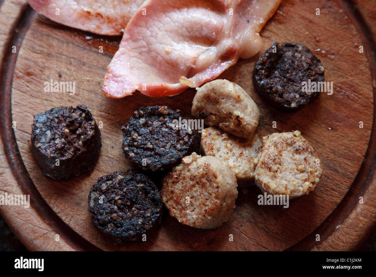 Boudin blanc, boudin noir et tranches de bacon sur conseil cuisine en bois Banque D'Images