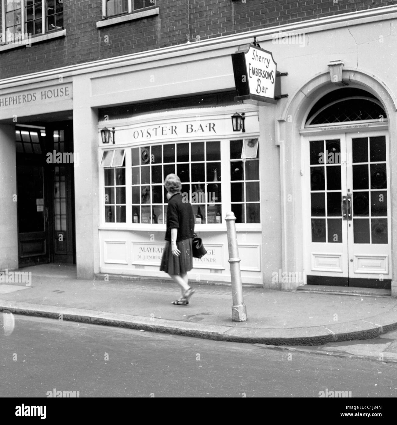 1960s, historique, une dame qui passe devant un Oyster Bar à Shepherd Market, Mayfair, W1 ans, la première à ouvrir ses portes à Londres. Banque D'Images