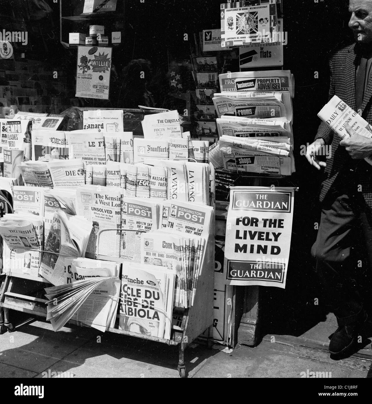 1966, journaux nationaux historiques, britanniques et étrangers exposés devant un agent de presse, lors de la coupe du monde de football en Angleterre. Banque D'Images