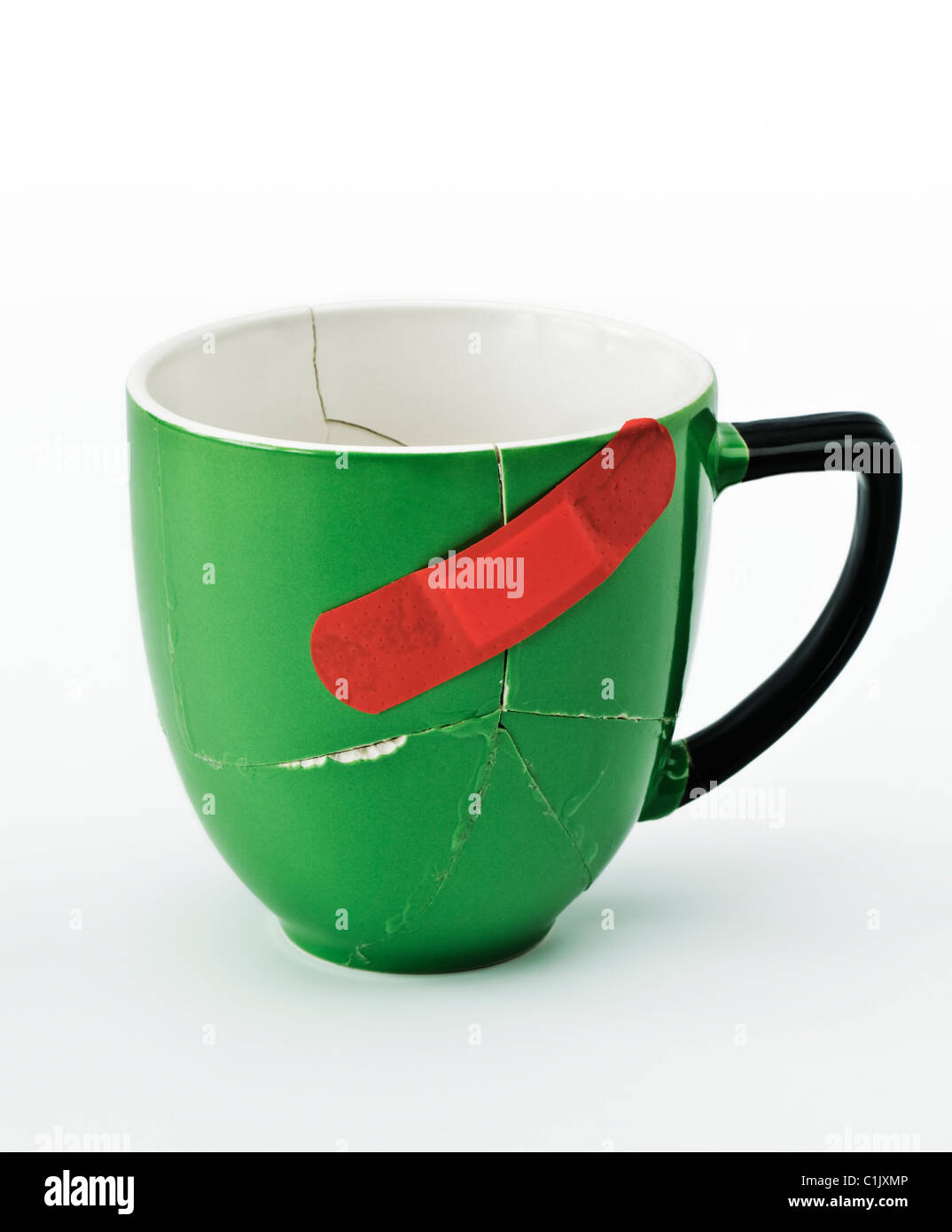 Mug vert cassées collées ensemble avec du plâtre rouge Banque D'Images