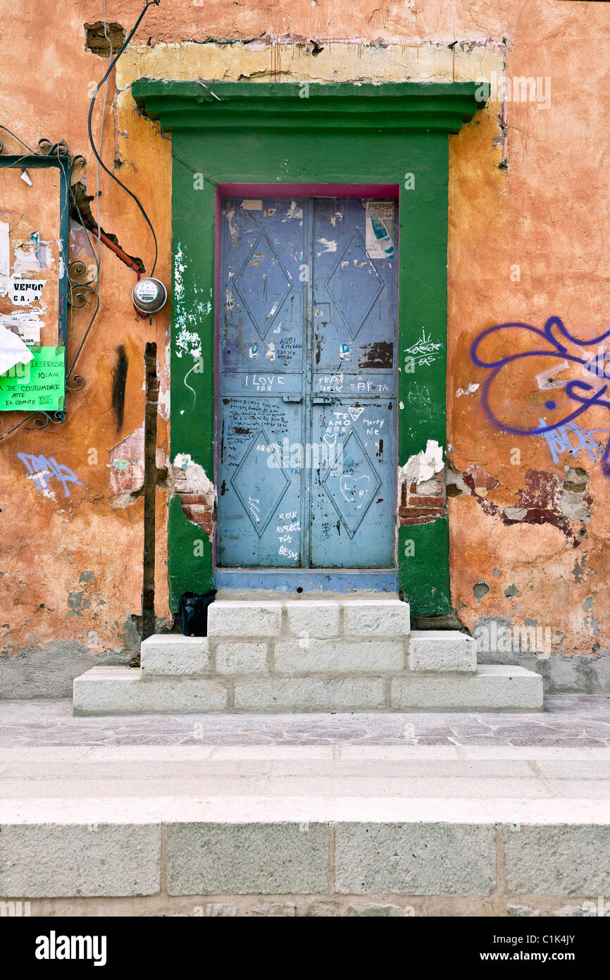 Vieux graffiti couvre les portes d'entrée qui ont de nouveaux marches de pierre dans le domaine de l'Artisan de Barrio Xochimilco Oaxaca au Mexique en cours de restauration Banque D'Images