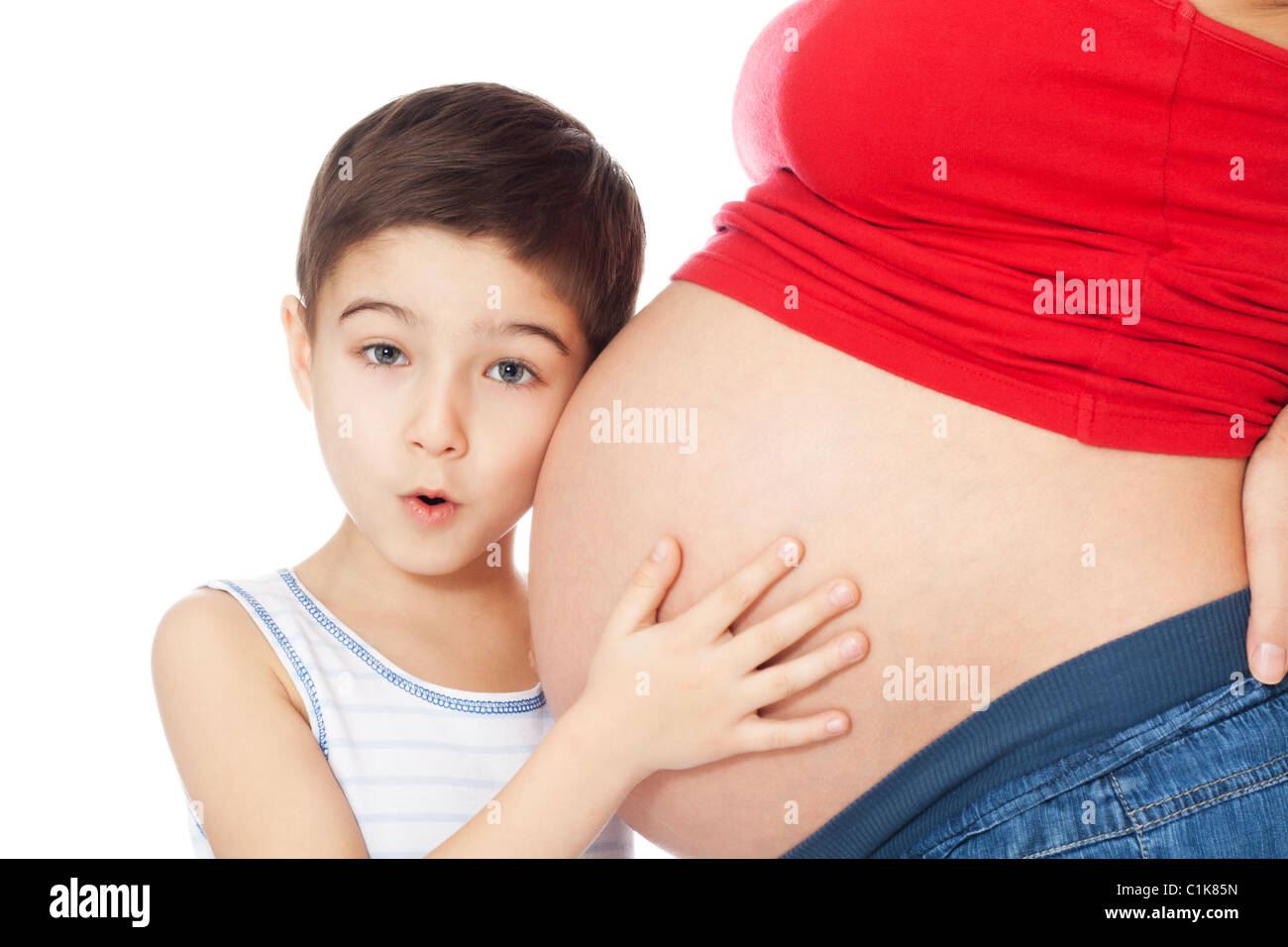 Surpris boy holding ventre de la mère avec les mains et l'écoute sur fond blanc Banque D'Images