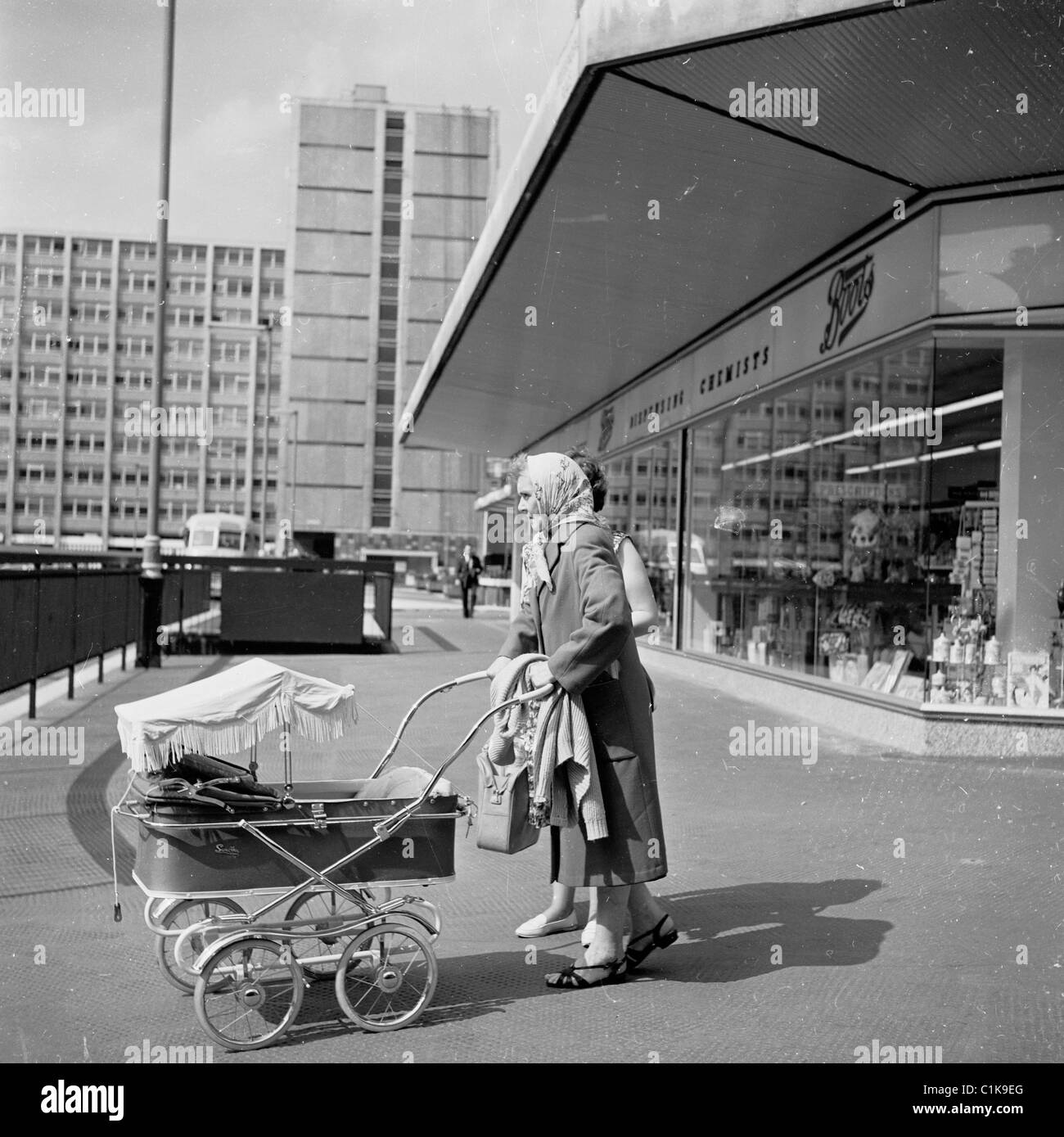 Années 1960. Londres. Dans ce tableau historique par J Allan en argent  comptant, une dame pousse un landau sur une route près d'un défilé de  boutiques Photo Stock - Alamy