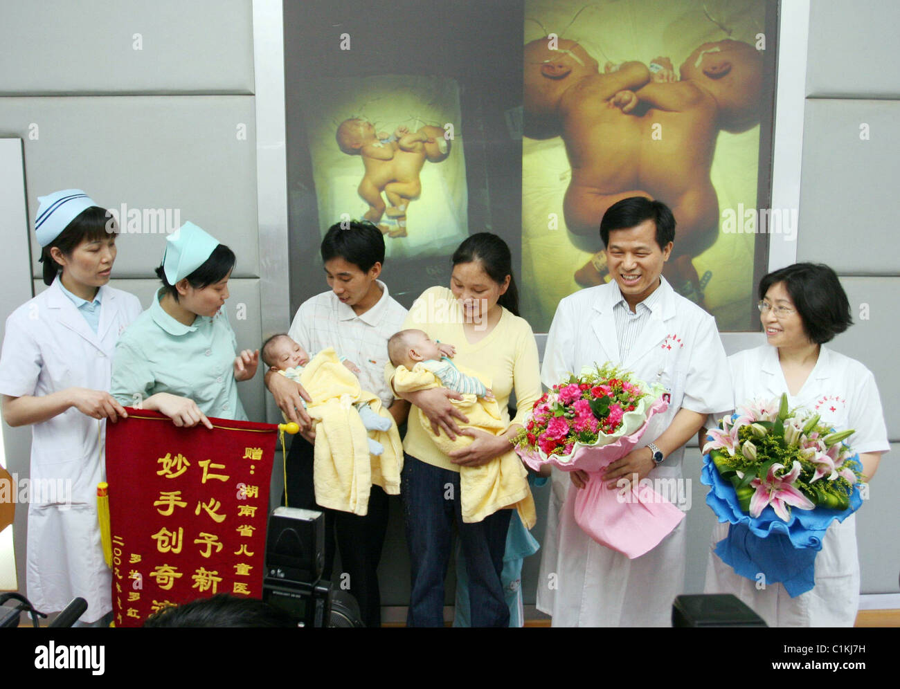 Jumeaux siamois sont enfin de retour en une paire de jumeaux siamois qui ont survécu à la chirurgie pour les séparer ont reçu leur congé de Banque D'Images