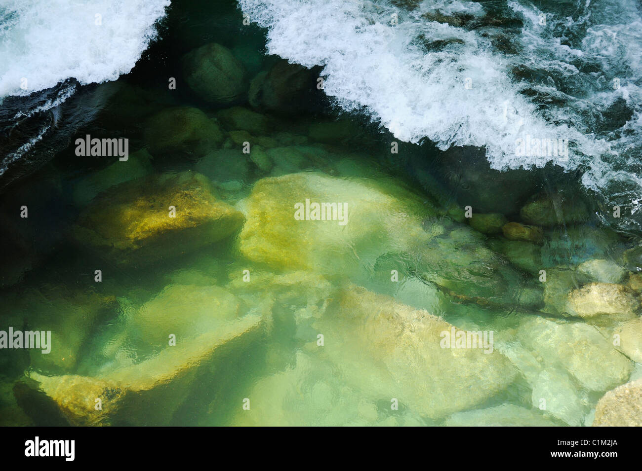 Les petites vagues à la mousse sur la partie peu profonde de la rivière. Banque D'Images