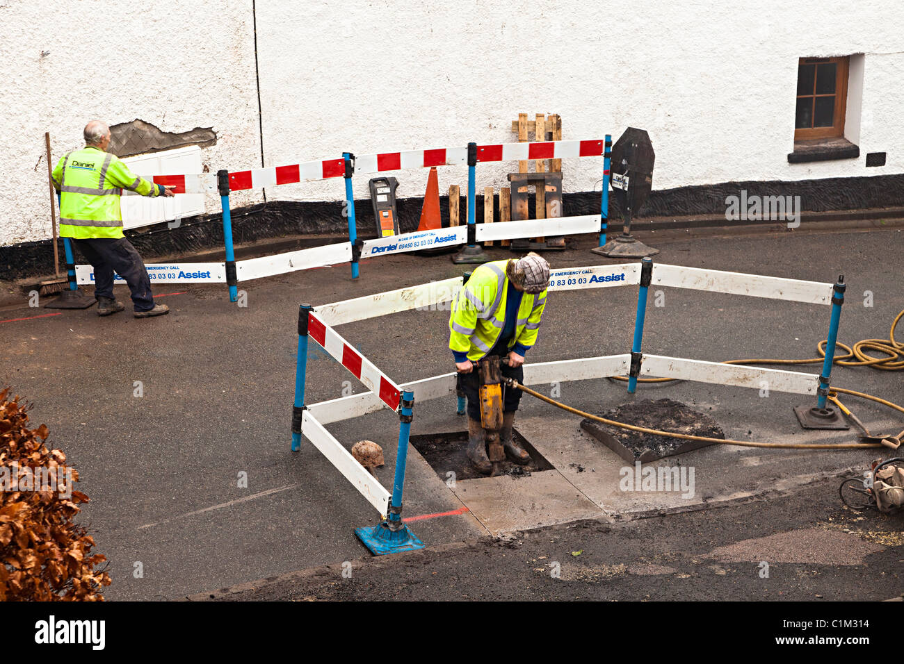 Les hommes de placer des barrières de sécurité et creuser jusqu'à jeter de la route services réseau Wales UK Banque D'Images