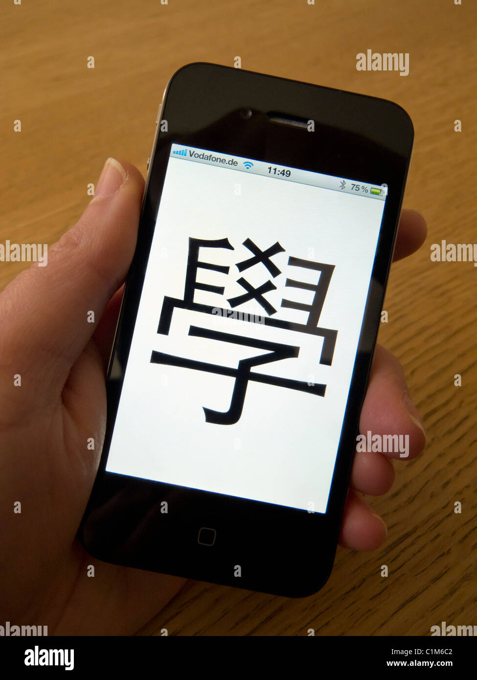 Étudiant en utilisant l'app à apprendre le mandarin caractères chinois sur un Apple Iphone 4G Téléphone intelligent Banque D'Images