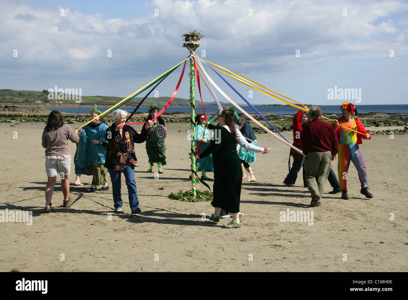 Danser autour du mât. L'Antiquité païenne d'une célébration de la fertilité étant effectuée sur la plage en face de St Michael's Mount. Banque D'Images