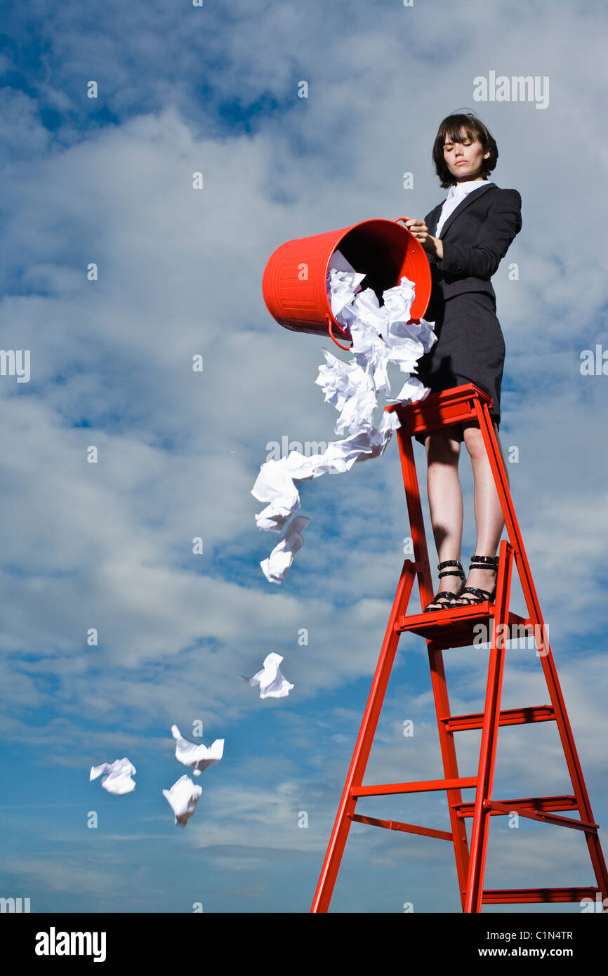 Femme à jeter les ordures de casier rouge standing Banque D'Images