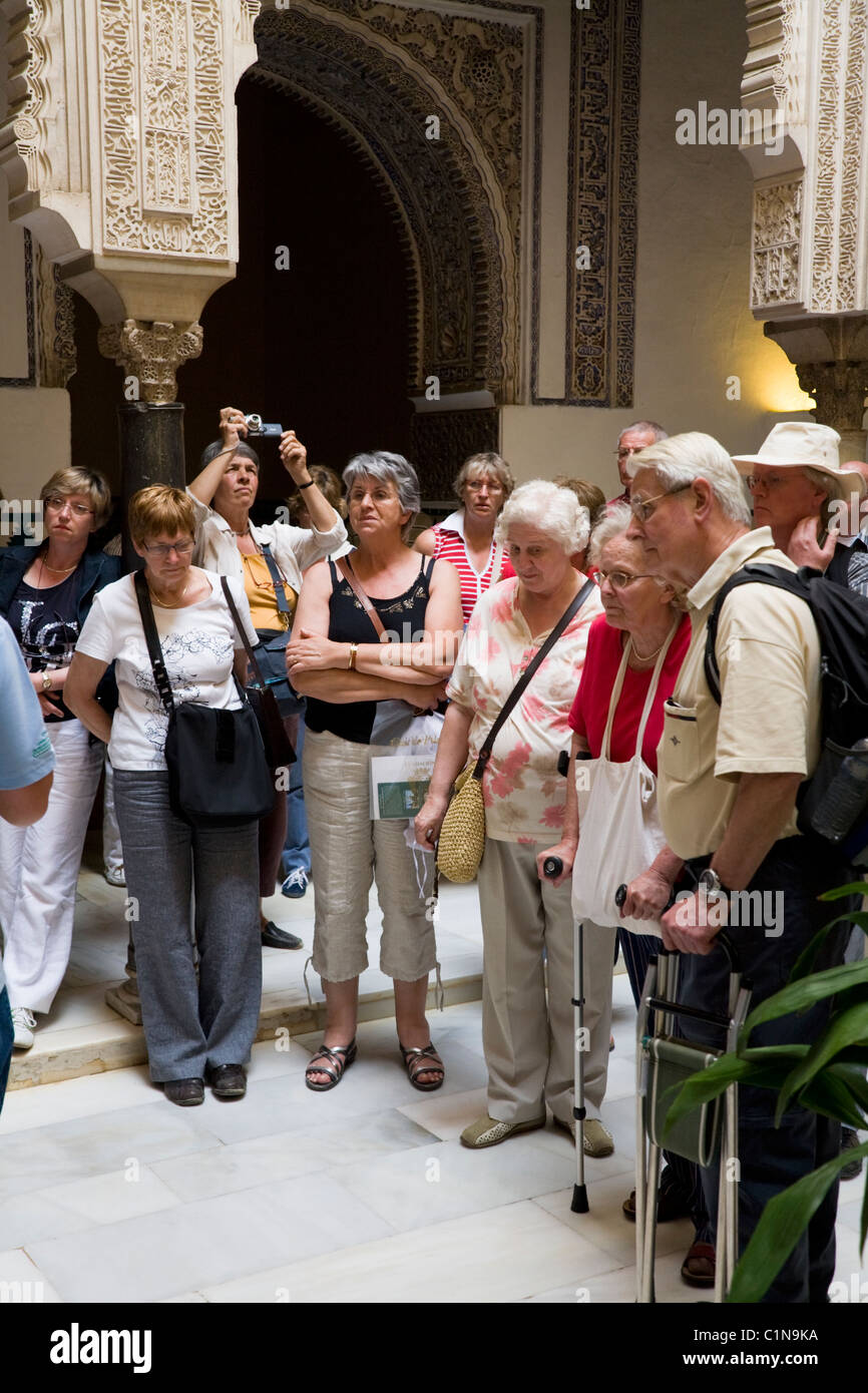 Groupe touristique / tour partie / moyen age / âgés de touristes à l'extérieur de la Cour. Alcazar de Séville / Séville. L'Espagne. Banque D'Images