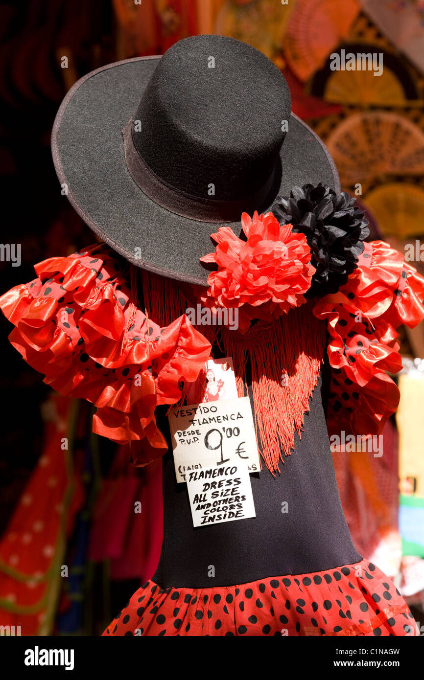 Le flamenco robe portée par un mannequin, & sun / Espagnol gaucho noir chapeau sombrero sur l'affichage à Sevilla boutique de souvenirs. Séville Espagne Banque D'Images