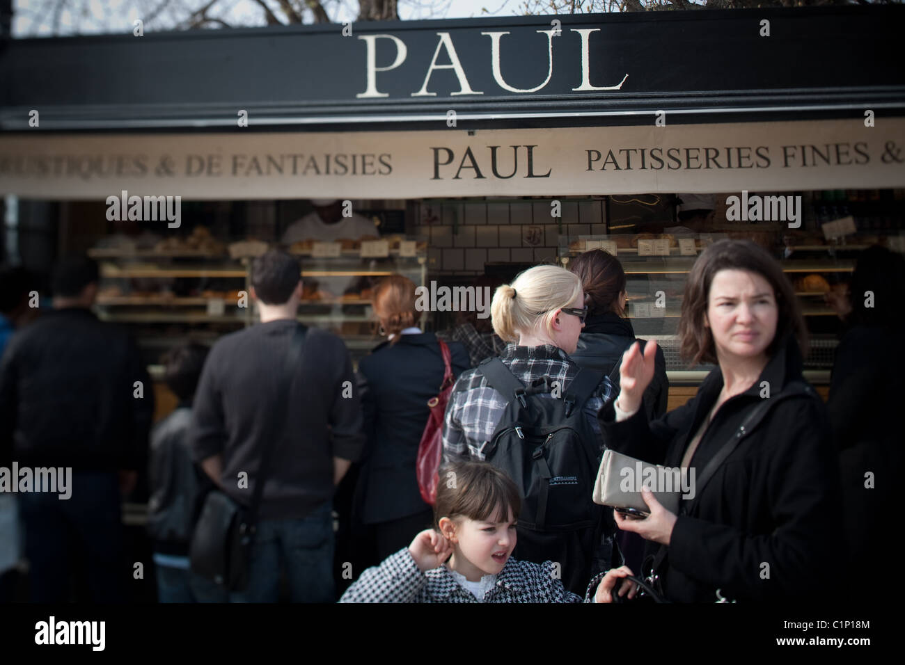 Les touristes affamés attendent en ligne à Patisserie Paul à l'extérieur de l'Hôtel du Louvre à Paris France Banque D'Images