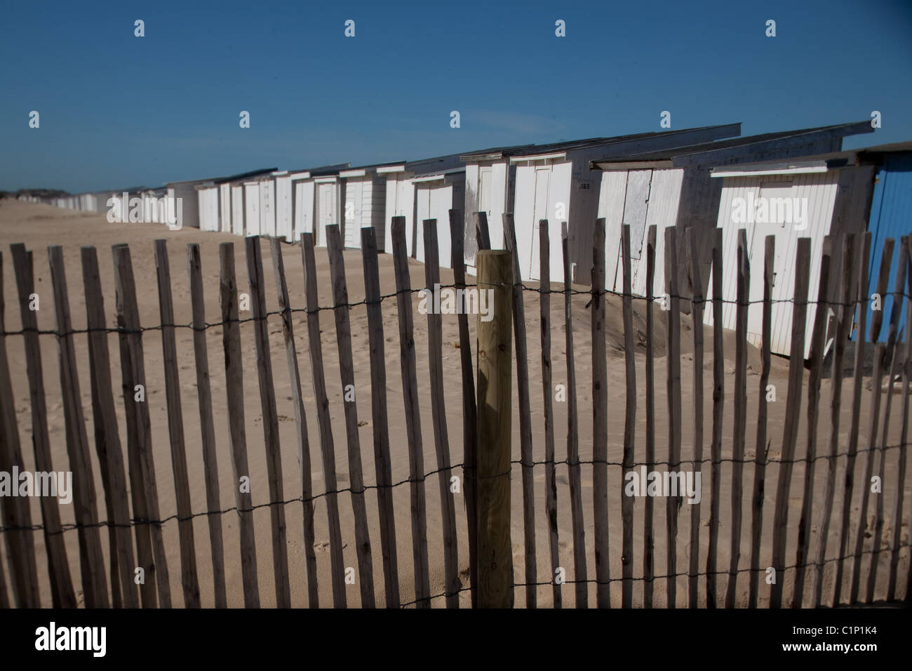Rangée de cabanes de plage et d'un stick clôture sur la côte nord de la France à Calais Banque D'Images