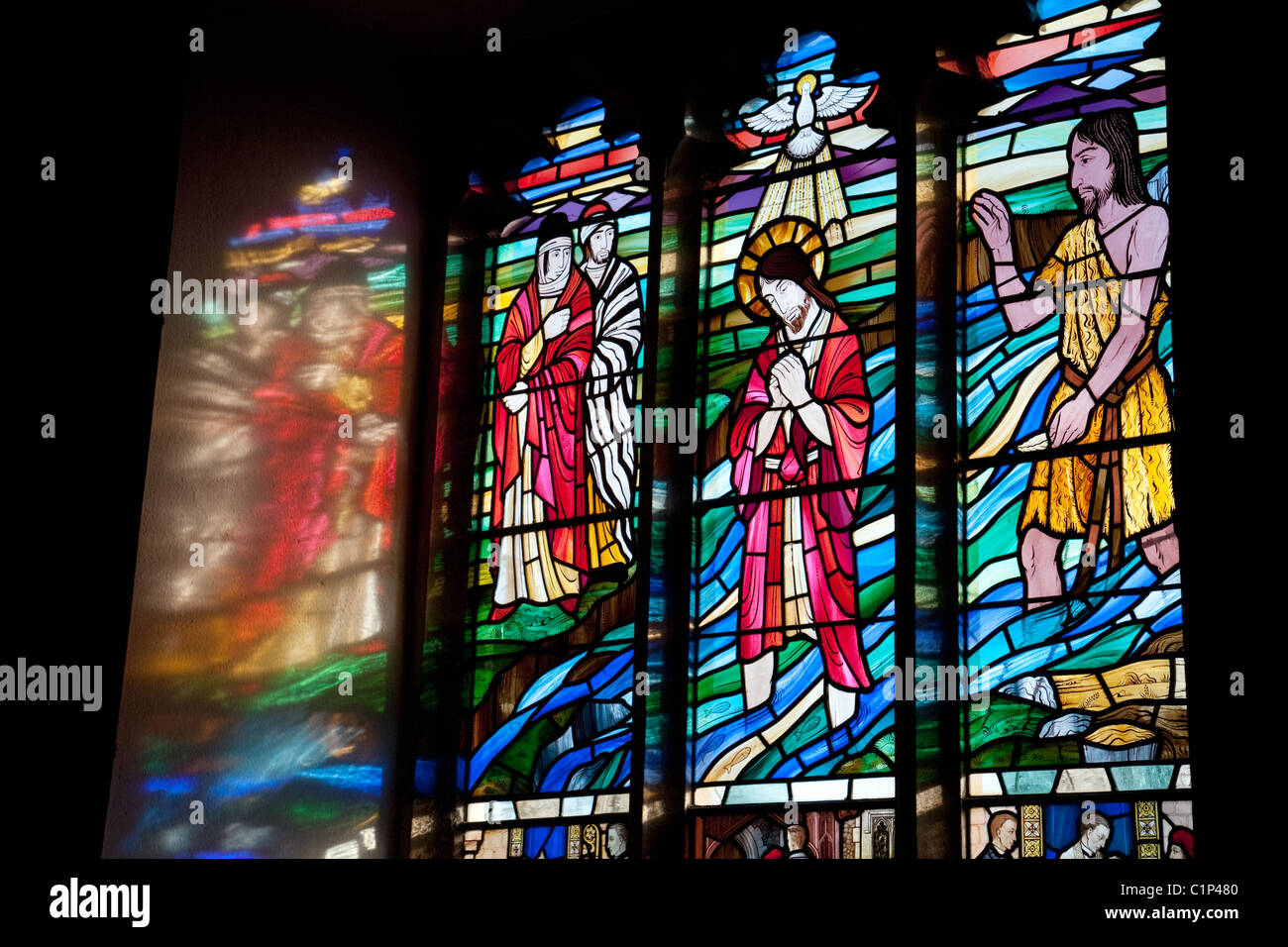 Vitrail avec la lumière du soir grâce à la diffusion en continu sur le mur de côté, l'église All Saints Village, Stock, Essex UK Banque D'Images