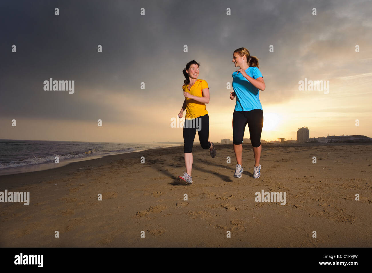 Les femmes jogging on beach Banque D'Images