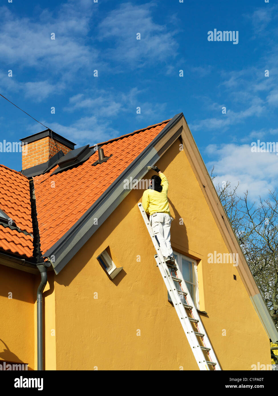 Man painting gable, low angle view Banque D'Images