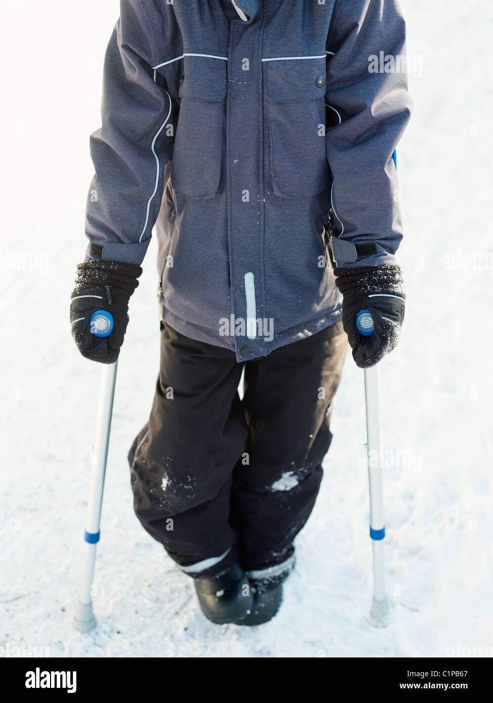 Boy walking avec béquille Banque D'Images