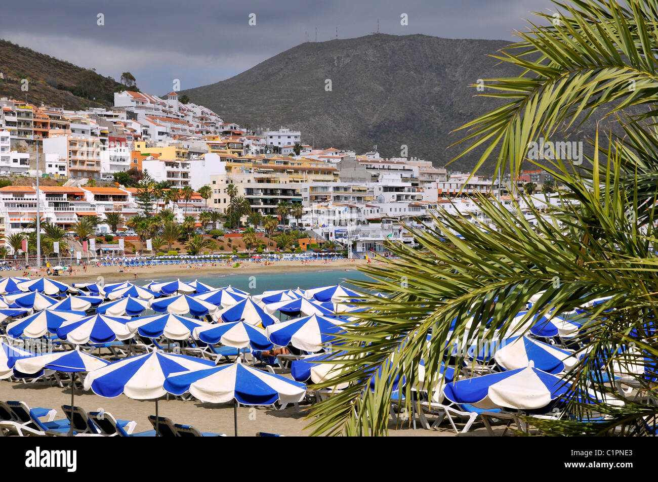 Des parasols sur la plage et la ville de Los Cristianos de la partie sud de Tenerife, dans les îles Canaries Banque D'Images