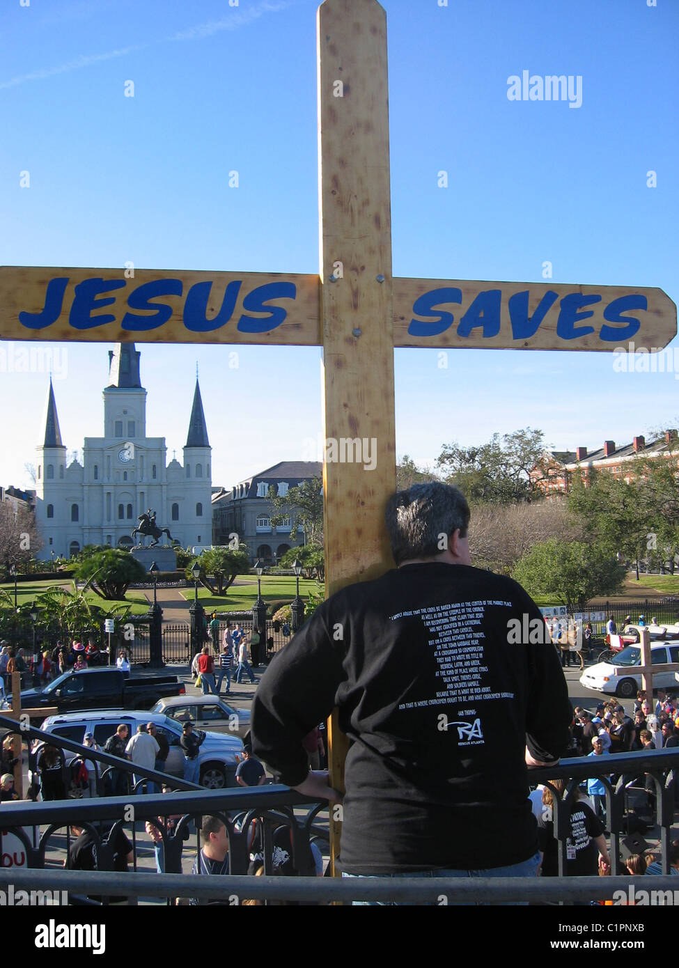 La Nouvelle Orléans. USA. Vue arrière d'un homme adulte manifestant religieux sur une croix en bois avec balcon holding les mots "Jésus sauve". Banque D'Images